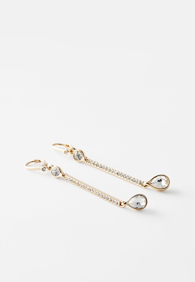 Goldfarbene Ohrringe mit langem, schlankem Design. Enthalten klare Edelsteine und eine Reihe kleiner Kristalle entlang der Länge für zusätzlichen Glanz.