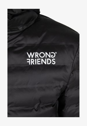 Chaqueta acolchada negra con textura de acolchado, que presenta un logo blanco "WRONG FRIENDS" en el área del pecho. Tejido suave y brillante.