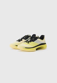 Yellow and black sports shoes with mesh upper, textured sole, streamlined design, and laces. Features three yellow stripes on sides.