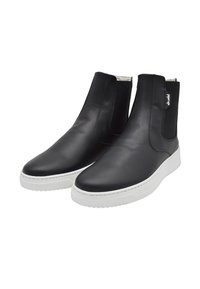 Botas de tobillo de piel negra con paneles laterales elásticos, suelas de goma blanca, punta redondeada y un diseño con costuras mínimas. Acabado con el logo de la marca.