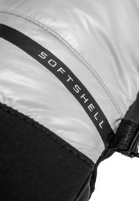 Giacca softshell con una parte superiore di colore argento lucido e una sezione inferiore nera testurizzata. Presenta un'etichetta nera prominente con la scritta "SOFTSHELL."
