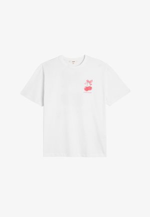 Weißes Baumwoll-T-Shirt mit einer pinken Kirsche-Grafik, die eine Schleife trägt, und dem Text "SÜSSE" unter dem Design. Kurze Ärmel und eine lockere Passform.