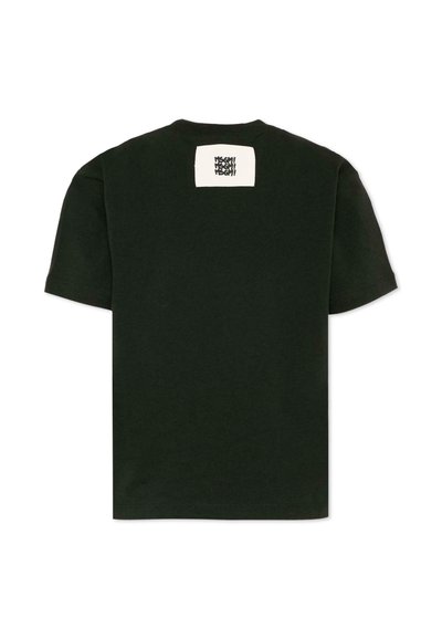 T-shirt noir à manches courtes avec un petit patch rectangulaire blanc près de l'encolure, portant un texte noir stylisé.