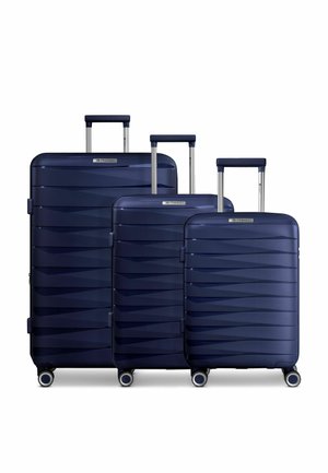 Three navy blue hard-shell suitcases with telescoping handles and four wheels, arranged in descending size order on a white background.