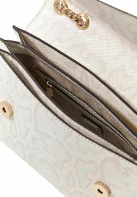 Sac à main blanc texturé avec motif serpent, ferrures dorées et plusieurs compartiments, y compris une poche zippée et un détail de fermeture à bouton.