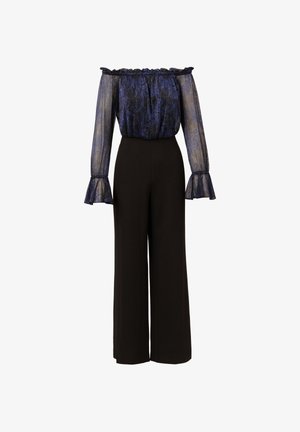 Off-shoulder doorschijnende blauwe blouse met pofmouwen, gecombineerd met hoge zwarte wijde broek. Textuurstof voegt detail toe.