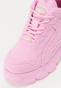 Sneaker in tessuto rosa con parte superiore testurizzata, dotata di lacci rosa, cuciture a contrasto, suola in gomma con dettagli rotondi e logo.