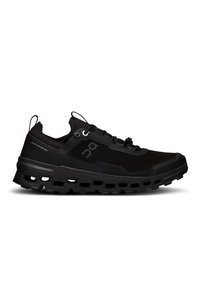 Chaussure de course noire avec un dessus en mesh structuré, une semelle intermédiaire prononcée et des rainures profondes dans la semelle extérieure pour une meilleure traction. Comprend des accents réfléchissants.