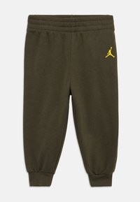 Ελαιόχρωμο παντελόνι φόρμας με ελαστική ζώνη και μανσέτες. Περιλαμβάνει ένα μικρό κίτρινο λογότυπο Jumpman στο αριστερό πόδι. Κατασκευασμένο από μαλακό, υφή ύφασμα.