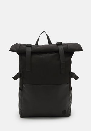 Zwarte roll-top rugzak van een gestructureerde stof, met een gladde leren onderkant, verstelbare banden en een handvat aan de bovenkant. Strak, modern design.