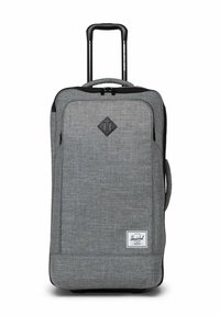 Valise à roulettes souple grise avec poignée rétractable, poche zippée avant, poignée latérale et étiquette de marque Herschel sur le bas à l'avant.