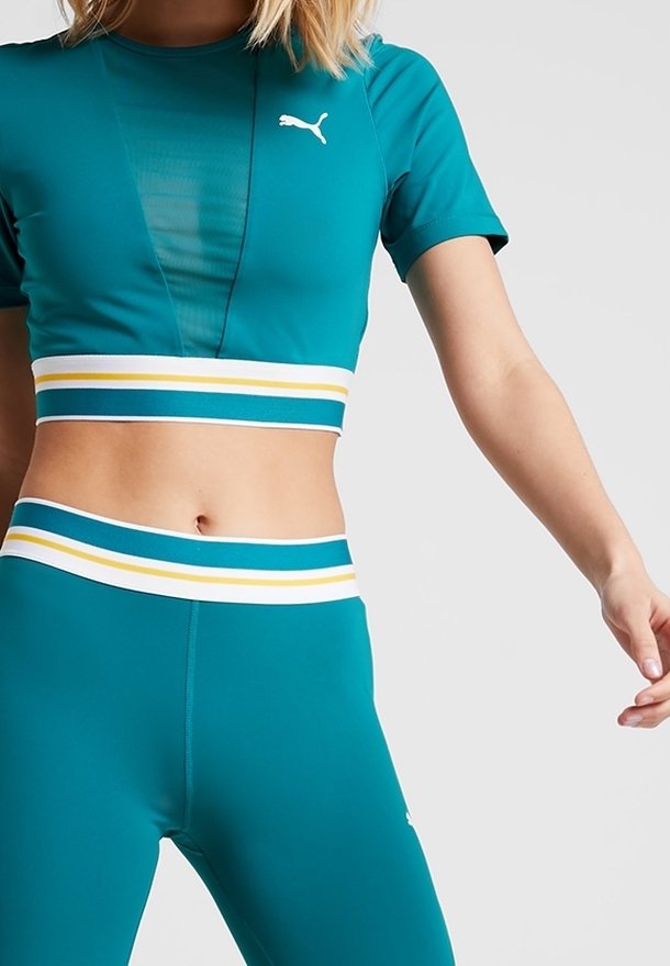 Teal atletisk crop top med korta ärmar, med en meshpanel. Teal högmidjade leggings med en randig midja i blått, gult och vitt.