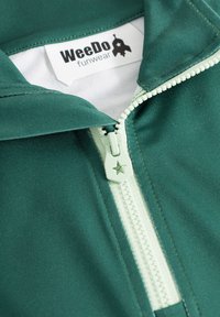Grüne Zip-Jacke mit einem weißen Reißverschluss und einem sternförmigen Zipper, aus glattem Material, mit einem Etikett, das "WeeDo funwear" liest.