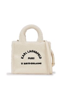 White, fluffy handbag with black embroidered text reading "KARL LAGERFELD PARIS 21 RUE ST-GUILLAUME," featuring short handles and a shoulder strap.