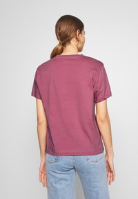 Kortärmad burgundy T-shirt i mjuk bomull med klassisk rund halsringning och en enkel, slät yta. Bakvy visas.