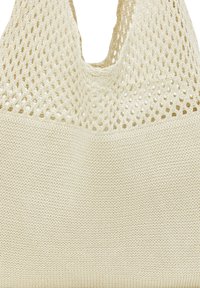 Beige gestrickte Einkaufstasche mit einer strukturierten Netzoberseite und solidem Boden. Verfügt über breite Griffe und ein leichtes Design, ideal zum Tragen.