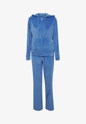 Tuta in velluto blu con felpa con zip e lacci, dotata di due tasche frontali, abbinata a pantaloni coordinati con vita elastica.