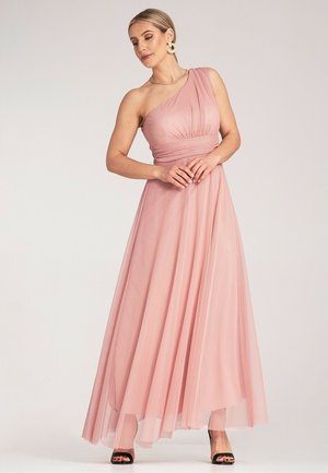 Ein pinkfarbenes, bodenlanges Kleid mit einem Schulterträger, auslagertem, leichtem Stoff, mit einem plissierten Oberteil und einem fließenden Rock. Schwarze Absätze sind sichtbar.