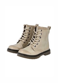 Botines beige hechos de cuero suave, con puntera redonda, ojales de metal, cordones y una suela texturada con un borde oscuro contrastante.