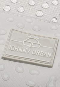 Szürke textúrájú szövet vízcseppekkel. A fehér kiemelkedő logó címke olvashatóan írja: "JOHNNY URBAN", alatta pedig "EST. 2016" van megnyomva.