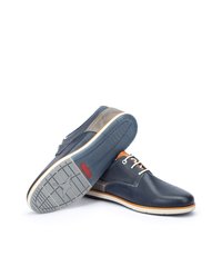 Navy blue leather shoes with a smooth texture, contrasting gray accents, orange laces, and a rubber sole featuring a patterned tread.