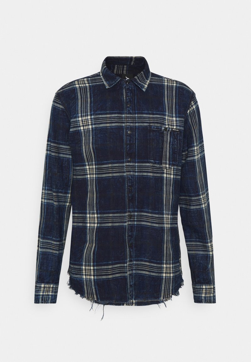 Chemise à manches longues à carreaux bleu marine et blanc avec boutons à l'avant, une poche poitrine et un ourlet effiloché en bas.