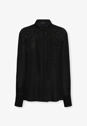 Blusa nera a maniche lunghe con bottoni, colletto a punta, ricamo decorativo a spirale e piccoli ornamenti a punti sul davanti e sulle spalle.