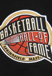 Toppa ricamata con la scritta "Basketball Hall of Fame" in nero, oro e rosso su uno sfondo di tessuto nero, con una grafica di pallacanestro.