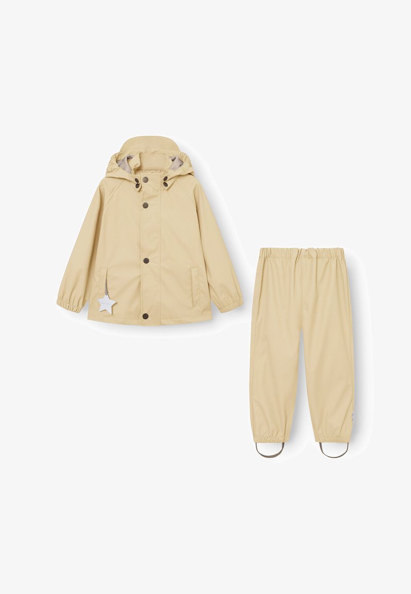 Hellbeige Regenjacke mit Kapuze, Druckknöpfen und einem Sternakzent. Passende hellbeige wasserdichte Hose mit elastischem Bund und Fußschlaufen.