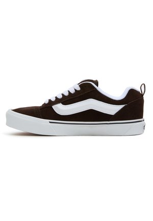 Brune ruskind sneakers med hvide snørebånd og sideløsning, med en hvid gummisål og sort accentlinje. Enkel design med bageste pull-tab.
