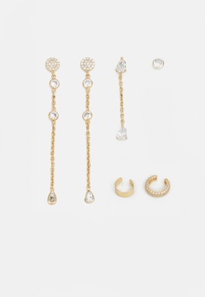 Ensemble de boucles d'oreilles dorées comprenant deux paires de boucles d'oreilles pendantes avec des pierres claires et une boucle d'oreille à ressaut avec un accent de pierre détaillé.