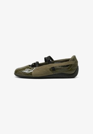Zapato plano verde oliva con parte frontal brillante y texturizada, panel lateral de ante, tiras elásticas negras y suela de goma negra, mostrado de lado.