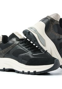 Black and white chunky sneakers with textured leather, mesh panels, thick soles, and "VIA VAI" branding on the heel section.