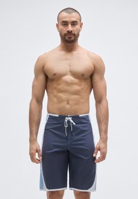 Pantaloni scurți de înot albăstri intens cu talie cu șnur, accente bleu deschis pe lateral și un finisaj neted, texturat al țesăturii.