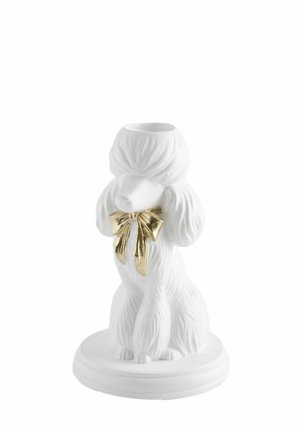 Hvid keramisk puddelfigur med detaljeret pelsstruktur og en skinnende guldbue om halsen, siddende på en rund base.