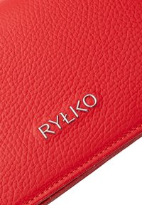 Portafoglio in pelle rossa con texture a ciottoli, caratterizzato da un logo argento "RYŁKO" impresso e cuciture visibili lungo i bordi.
