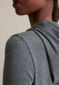 Grijze geribbelde stoffen hoodie met een losse pasvorm. Voorzien van een gedrapeerde halslijn en een textuur met reliëf, wat zorgt voor een zachte en comfortabele uitstraling.