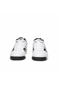 Scarpe sportive bianche con accenti neri, dotate di una tomaia in materiale mesh e sintetico, design con lacci e suola in gomma nera testurizzata.