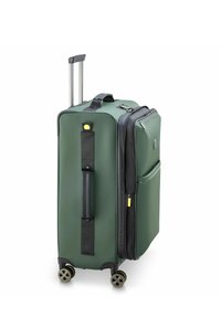 Valise rigide verte avec une poignée rétractable, accents noirs, deux roues et compartiments zippés. Dispose d'une poche latérale et d'un détail de logo.