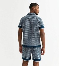 Chemise à manches courtes avec motif bleu marine et blanc assortie à un short, avec des manches retournées et un col, arborant un design géométrique.