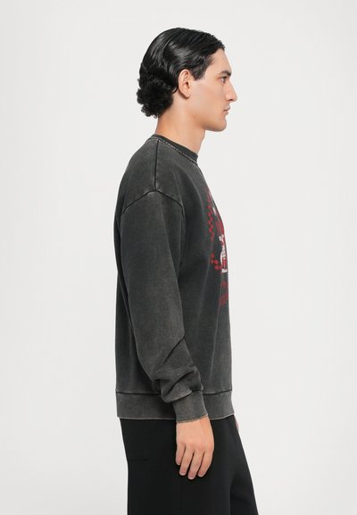 Dunkelgrauer Pullover mit Rundhalsausschnitt und Rippbündchen, mit einem grafischen Design in Rot und Schwarz auf der Vorderseite. Glatte Textur und lässige Passform.