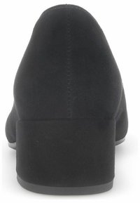 Scarpa nera in suede con tacco alto, punta tondeggiante e tacco a blocco. Dettaglio delle cuciture sul retro con una texture liscia.