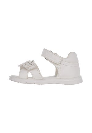Sandalias de cuero blanco con diseño floral troquelado, detalle de gema, correa ajustable y suela plana. Adecuadas para uso informal.