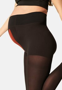 Zwarte leggings met een hoge tailleband, voorzien van een getextureerd rood paneel en soepel, rekbaar materiaal dat het lichaam omarmt.