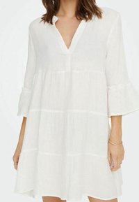Witte, knielange jurk met een V-hals, uitlopende mouwen en een gelaagd ontwerp. Gemaakt van lichtgewicht stof met een zachte, gestructureerde afwerking.