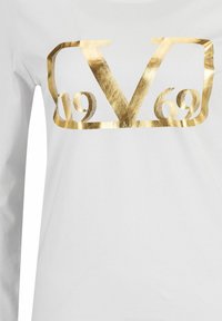White long-sleeve shirt featuring a large, metallic gold logo with "V69" and "ITALY" in stylized letters, smooth texture and minimal design.