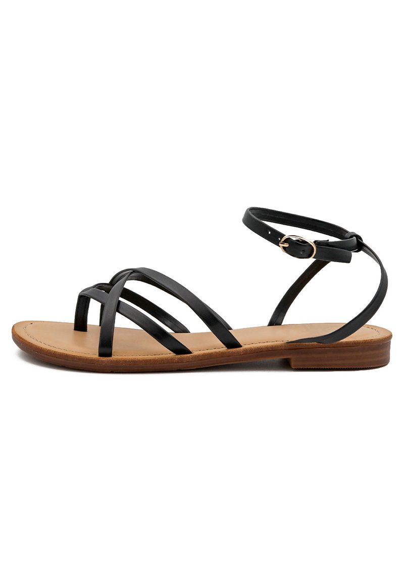 Sandalo nero con cinturini e suola piatta. Presenta un design a cinturini incrociati sottili e una cinghia alla caviglia con fibbia. Sottopiede marrone e costruzione leggera.