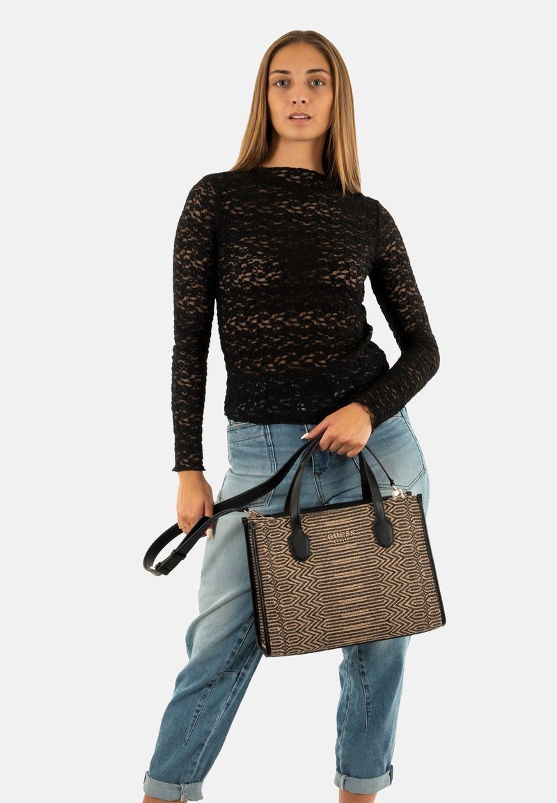 Borsa a tracolla beige con motivo e dettagli neri, forma rettangolare alta, doppie maniglie robuste, superficie testurizzata e dettagli in metallo argentato.