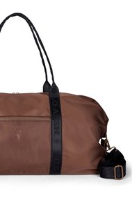 Hnědá taška typu duffel z voděodolného materiálu, s dvěma černými páskovými rukojetěmi, nastavitelným ramenním popruhem a reliéfním logem.