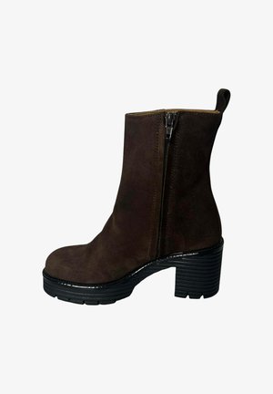 Botín de ante marrón con cierre lateral, tacón negro apilado y suela de plataforma texturizada, con un acento suave alrededor de la base.